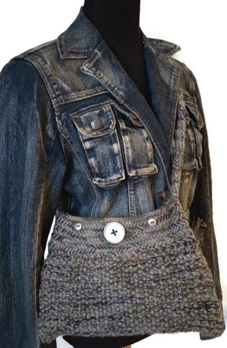 May include: A brown and gray knitted bag with a large button closure. The bag is worn over a denim jacket.