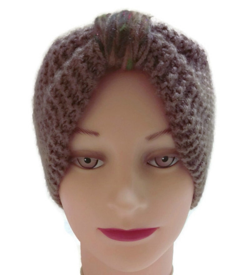 K&ouml;nnte beinhalten: Ein braunes Strick Stirnband mit einem mehrfarbigen Garn Detail. Das Stirnband wird auf einem Mannequin Kopf getragen.