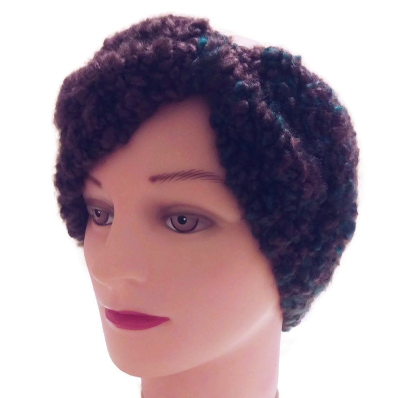 May include: A brown and teal knitted headband with a fluffy texture.