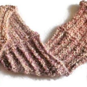 Op de afbeelding: Een zachte, gebreide sjaal in tinten roze, bruin en beige. De sjaal is gemaakt met een textuur-steek en heeft een lang, vloeiend ontwerp.