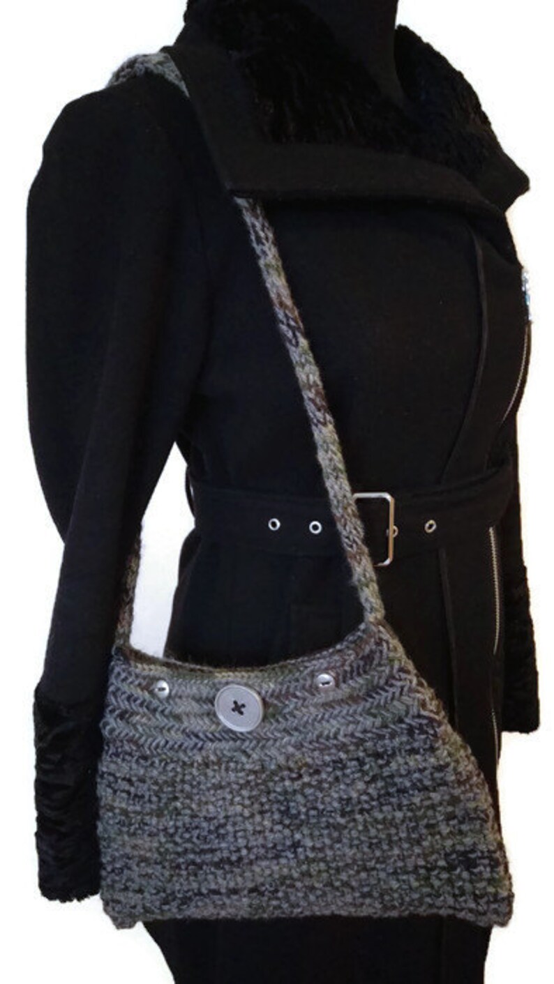 May include: A black coat with a fur collar and a gray knitted bag with a button closure. The bag is worn over the shoulder.