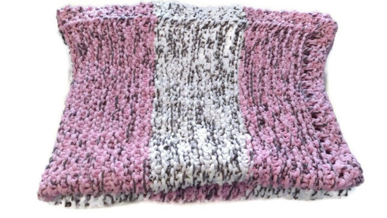May include: A soft, chunky knit throw blanket with stripes of pink, white, and gray yarn.