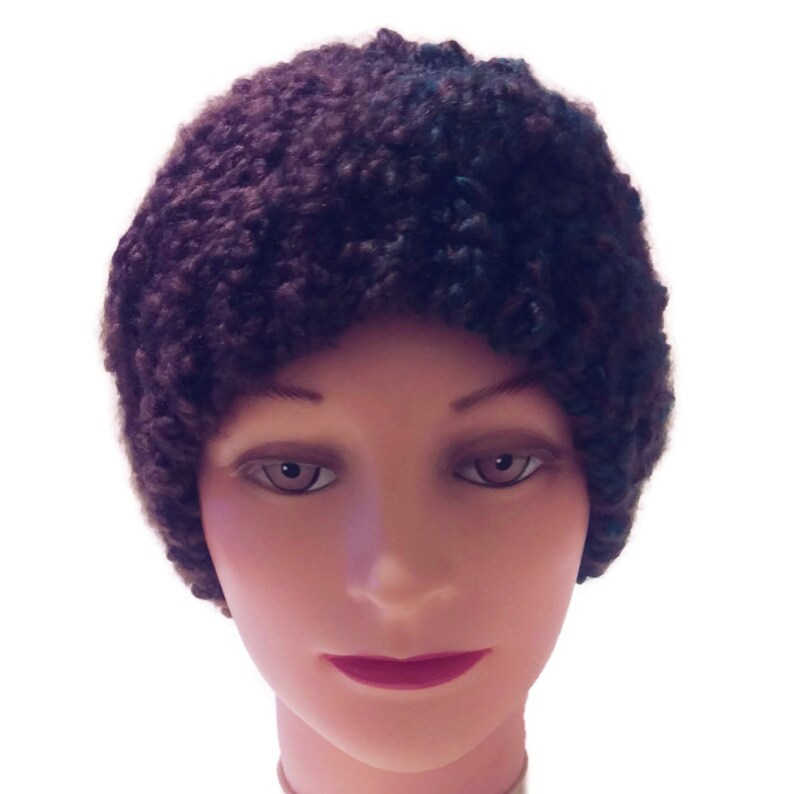 May include: A brown and black knitted beanie hat with a fluffy texture.