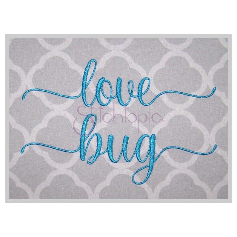 May include: Embroidered design on a gray fabric background. The design is in a cursive font and says "love bug" in blue thread.