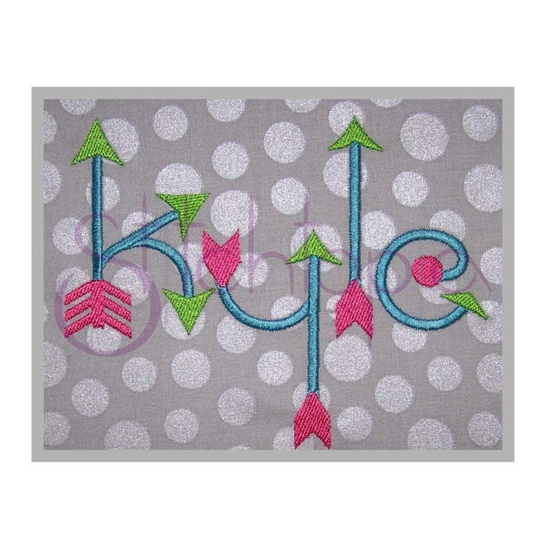 May include: Embroidered design of the name "Kyle" with turquoise, green, and pink arrows. The design is on a gray background with white polka dots.