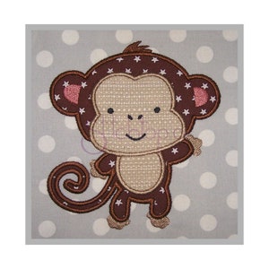 May include: Embroidered brown monkey with pink ears and white stars on a brown background. The monkey has a brown tail and is standing on a gray background with white polka dots.
