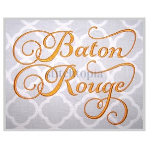 Puede incluir: Diseño bordado de las palabras "Baton Rouge" en una fuente de letra dorada.
