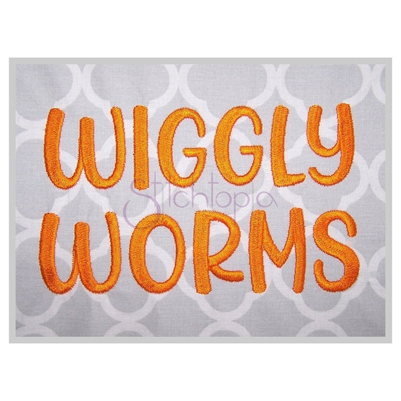 May include: Orange embroidered text on a gray background that reads "Wiggly Worms".