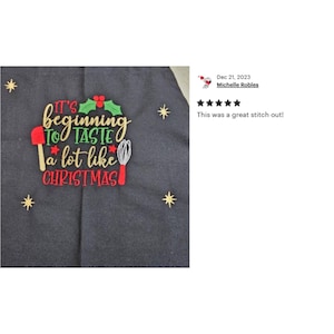 May include: A black and gray Christmas-themed kitchen towel with red and green embroidery that reads "It's beginning to taste a lot like Christmas".
