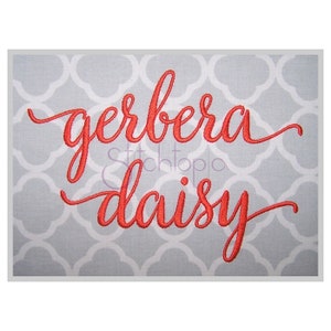 May include: A gray background with a white quatrefoil pattern. The words "gerbera daisy" are embroidered in a vibrant red script. The text is centered, creating a visually appealing design.
