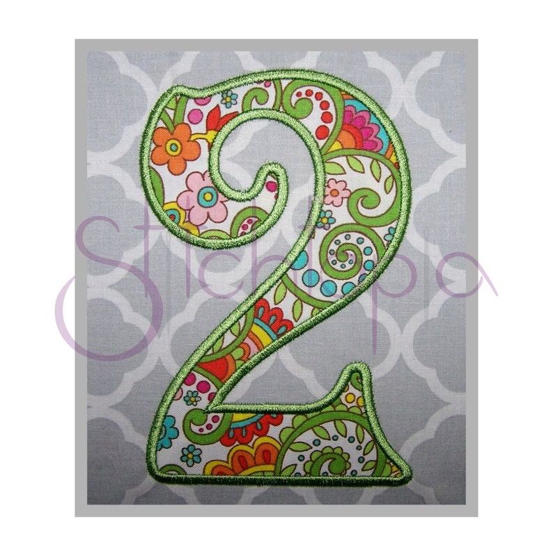 May include: A green outlined number two with a colorful paisley pattern inside. The number is on a gray background.