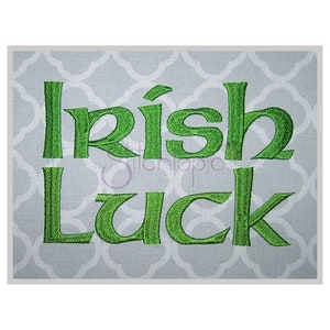 Puede incluir: Texto bordado en verde sobre un fondo gris que dice "Irish Luck".