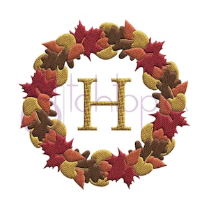 May include: Embroidered autumn wreath with a gold letter H in the center. The wreath is made of red, orange, yellow, and brown leaves.
