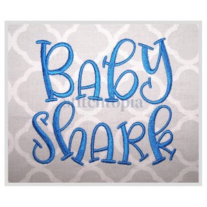 May include: Blue embroidered text on a gray fabric background that reads "Baby Shark".