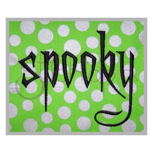May include: Black embroidered "spooky" text on a green background with white polka dots.