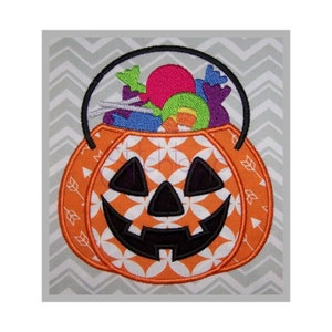 May include: Orange pumpkin-shaped Halloween trick-or-treat bucket with a black smiling face and a black handle filled with colorful candy.