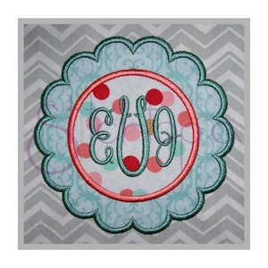 May include: A teal blue scalloped circle with a pink and green polka dot circle inside. The inner circle has a teal blue monogram "EUG" in the center.