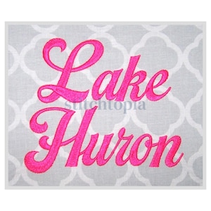 Puede incluir: Diseño bordado de "Lake Huron" en fuente cursiva rosa sobre un fondo de tela gris.