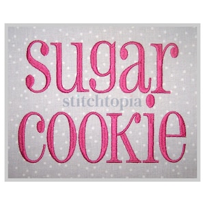 May include: Embroidered design on a light gray fabric with white polka dots. The design reads "sugar cookie" in pink.