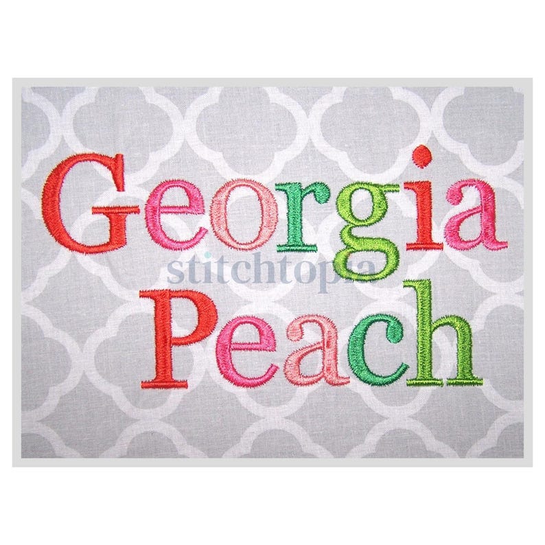 May include: Embroidered design featuring the words "Georgia Peach" in a colorful font. The letters are outlined in red, pink, green, and light blue.