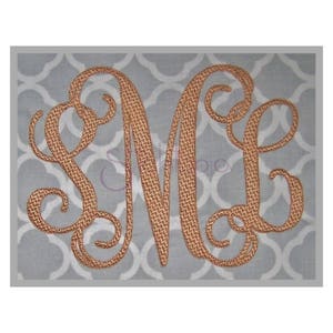 May include: A monogram with the letters "S M L" in a script font. The letters are embroidered in a brown thread on a gray fabric background.