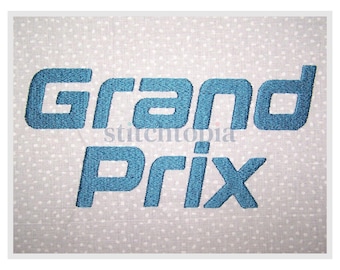 May include: Embroidered text on a light gray fabric with white polka dots. The text reads "Grand Prix" in a bold, teal blue font. The word "stitchtopia" is in a smaller font between the words.