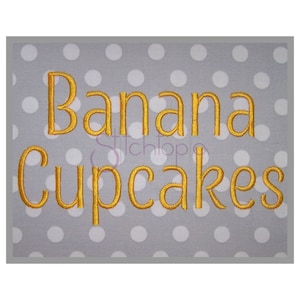 May include: A gray background with white polka dots features the text "Banana Cupcakes" in gold embroidery.