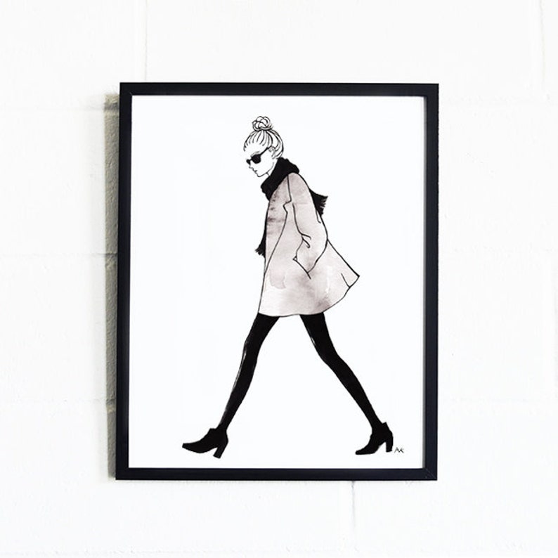 Pu&ograve; includere: Illustrazione in bianco e nero di una donna che indossa un lungo cappotto, occhiali da sole e una sciarpa. Sta camminando con i capelli raccolti in uno chignon.