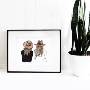 May include: A framed illustration of two women wearing brown hats, standing back to back. The woman on the left is wearing a black shirt and the woman on the right is wearing a white shirt.
