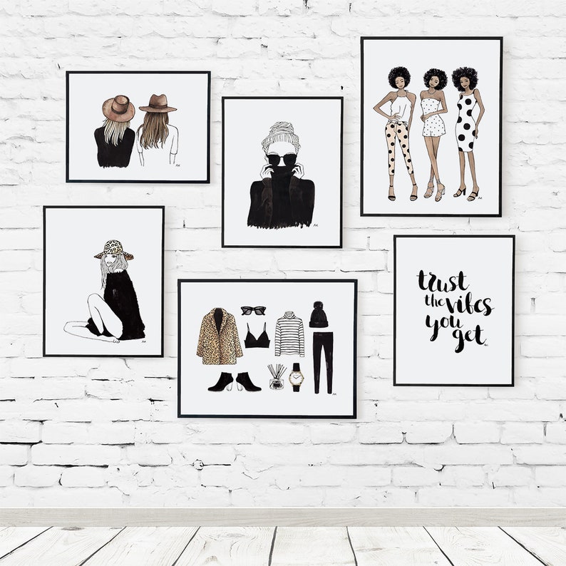 May include: A white brick wall with six framed prints. The prints feature black and white illustrations of women wearing various outfits and accessories. One print has the text "Trust the vibes you get".
