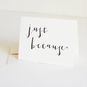 May include: A white card with black calligraphy that reads "just because".