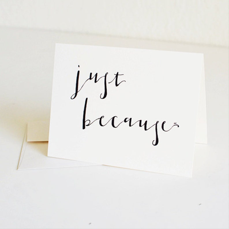 May include: A white card with black calligraphy that reads "just because".