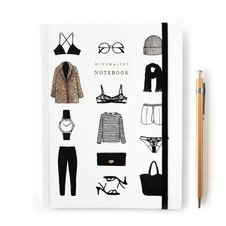 May include: A white notebook with a black elastic band closure. The cover features black and white illustrations of various fashion items, including a leopard print coat, a striped shirt, a pair of sunglasses, a watch, a bra, underwear, a hat, a scarf, shorts, a purse, and a pair of sandals. The text "MINIMALIST NOTEBOOK" is printed in black on the cover.