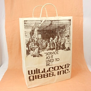 May include: A brown paper bag with a white handle. The bag has a black and white illustration of a store interior with people inside. The text "SERVICE AS IT USED TO BE..." is printed in brown on the bag. The text "WILLCOX & GIBBS, INC." is printed in brown on the bottom of the bag.