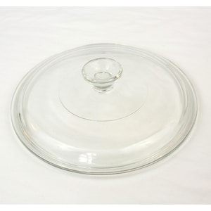 Puede incluir: Una tapa de vidrio transparente con un pequeño asa redondeada. La tapa circular está diseñada para una olla o sartén. El vidrio transparente permite ver el contenido. El asa también es de vidrio transparente.