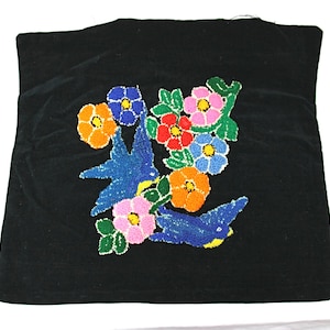 May include: Black velvet pillow with embroidered colorful flowers and blue birds.