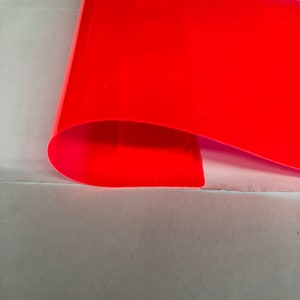 May include: A bright, neon pink sheet of plastic material. The sheet is folded in half and the edges are visible.