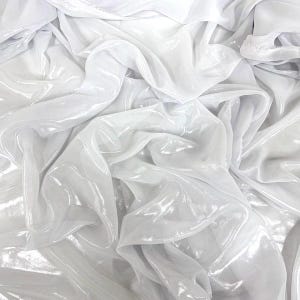 May include: Close-up of white, shimmering fabric with gentle folds and a reflective surface. The fabric is draped, creating a flowing, textured effect. The material has a subtle sheen, possibly satin or a similar finish.