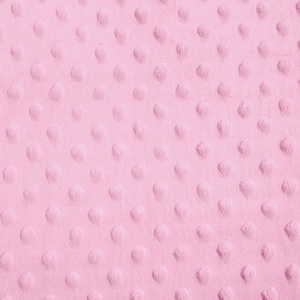 May include: A close-up of a pink fabric with a textured pattern of small, raised circles.