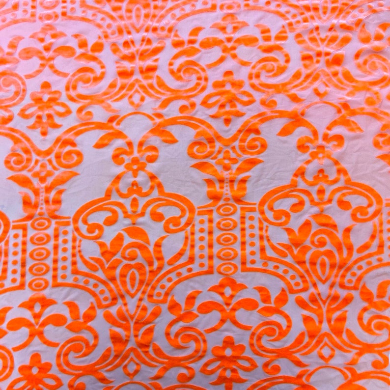 May include: Orange and white fabric with a damask pattern.