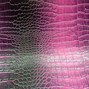 May include: Close-up of a textured surface with a crocodile skin pattern. The color gradient transitions from dark purple to bright pink. The pattern is made up of small, irregular shapes.