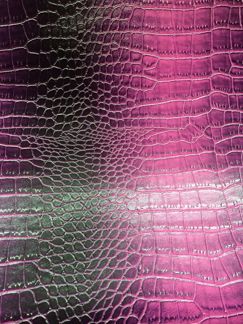 May include: Close-up of a textured surface with a crocodile skin pattern. The color gradient transitions from dark purple to bright pink. The pattern is made up of small, irregular shapes.