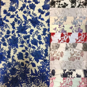 Puede incluir: Una variedad de muestras de tela de encaje floral en diferentes colores, incluyendo azul, negro, gris, blanco, rojo y rosa. El encaje presenta un delicado patr&oacute;n floral con flores 3D y cuentas.