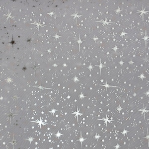 May include: Silver glitter stars on a sheer, light gray fabric. The fabric is translucent and the stars are scattered randomly across the surface.