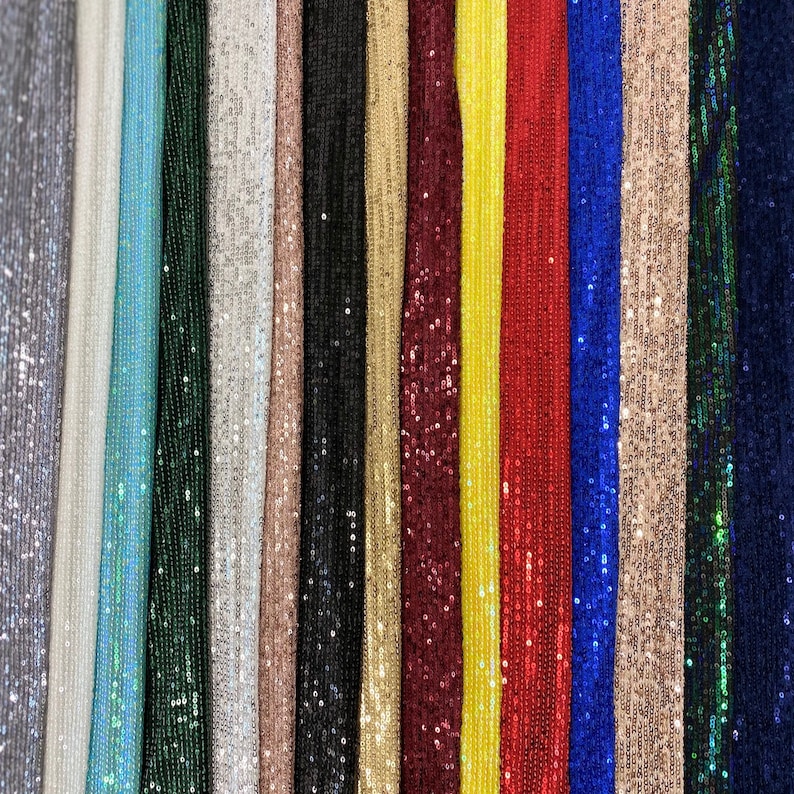 May include: A variety of sequined fabrics in different colors, including silver, light blue, green, white, beige, black, gold, burgundy, yellow, red, blue, and teal.