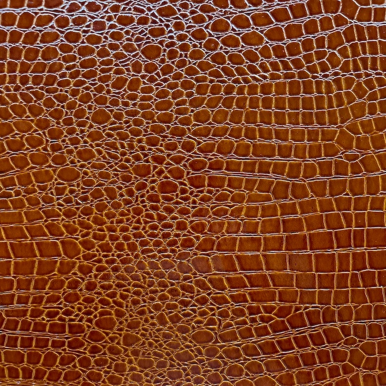 May include: Brown faux leather with a crocodile skin pattern.