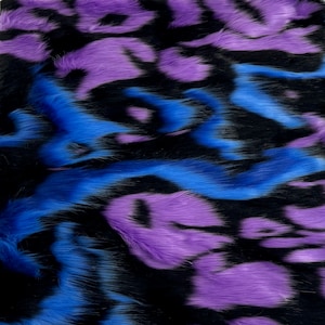 May include: A close-up of a fabric with a black, blue, and purple abstract pattern. The fabric has a fuzzy texture, resembling faux fur.