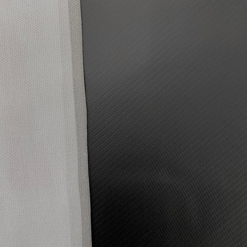 May include: Close-up of a gray textured fabric next to a black textured fabric.