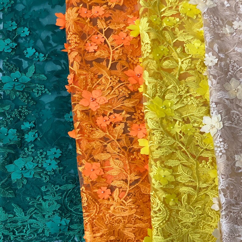 Puede incluir: Cuatro tipos diferentes de tela de encaje con patrones florales. Las telas son verde, naranja, amarilla y beige.
