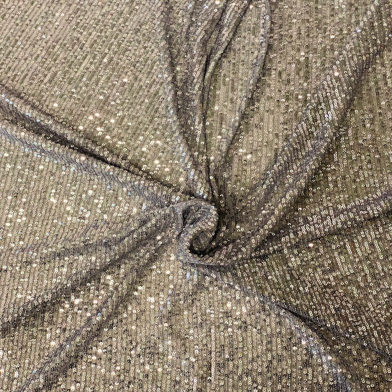 May include: Silver sequined fabric with a subtle vertical pattern. The sequins are small and closely spaced, creating a shimmering effect.